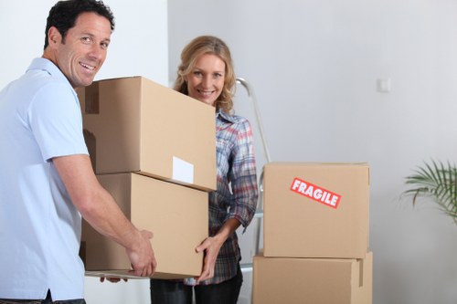 A mover wearing PPE while handling boxes during a van removal job